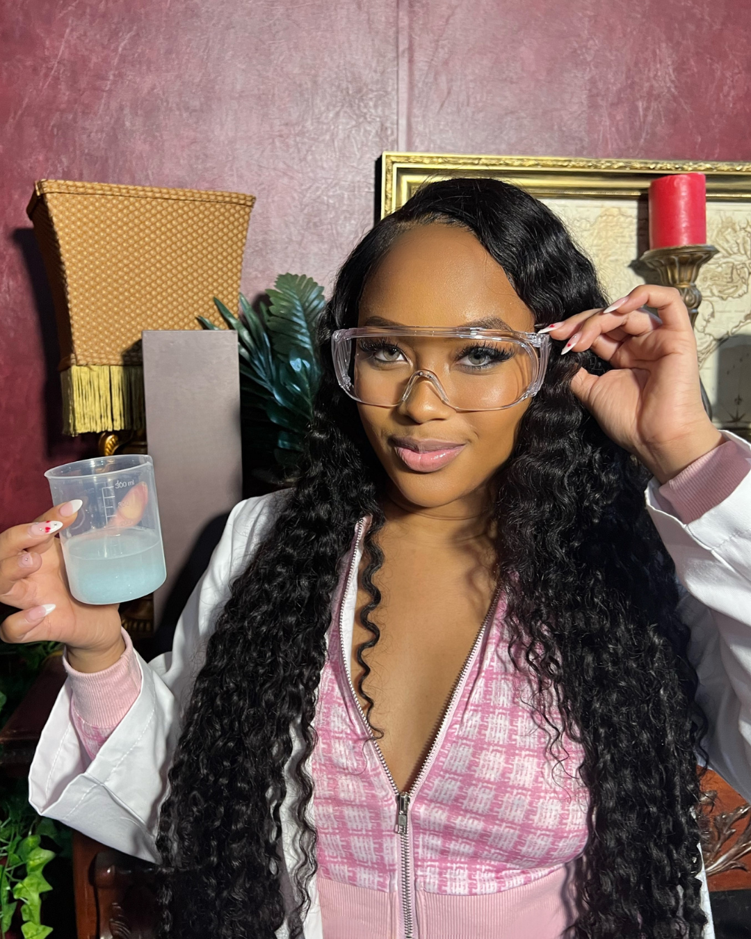 Shadie Ellington, Machisma founder and chemical engineer, in lab coat and safety glasses holding a beaker